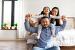 © Богдан Маліцький - Korean dad holds his little daughter in his arms and depicts flight, child plays with his parents and rejoices at home