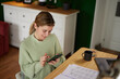 © Stockphotodirectors - Happy young businesswoman text messaging from home office