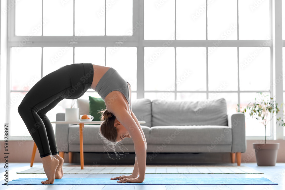 Sporty young woman doing yoga  at home