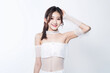 Portrait of Cute Asian Woman, She raises her arm to show her Smooth armpit skin and looks at the camera on a White background in Studio light. generative AI.