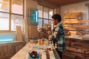 Wall Mural - Carpentering entrepreneur holding project toy in hand.