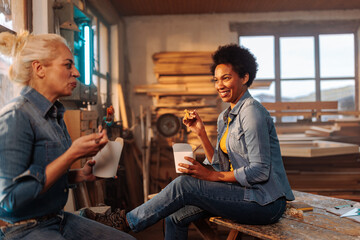 Wall Mural - Joyful carpenters eating lunch in workshop.