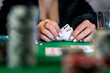 © RomanR - beautiful young girl is sitting at a poker table with cards in her hands.