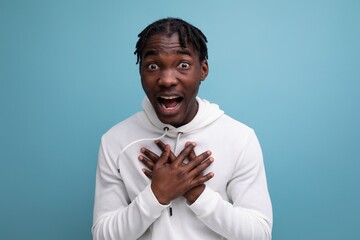 joyful energetic happy dark-skinned young brunette man in a white sweatshirt on the background with copy space