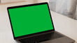 © DomenicoFornas - A Green Screen Laptop on a White Table at Home