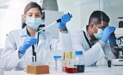 Poster - Putting our skills to work. two young researchers working in a laboratory.