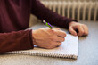 © Astrakan Images - Man studying and writing in notebook