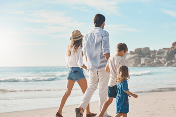 Wall Mural - This is the perfect family bonding date. Rearview shot of an unrecognizable couple holding hands with their two children and walking along the beach.