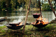 © Astrakan Images - Food cooking in pot and pan over campfires