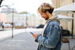 © Andrii Zastrozhnov - Positive young bearded male student with a phone in his hands on a city street.