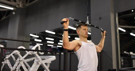 Wall Mural - Athlete man lifting weight on simulator in gym 4k movie slow motion. Healthy lifestyle and sport concept