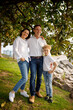 © Natalia Dombrovschi - Stylish casual family in the park under magnolia tree near Italian Garda lake