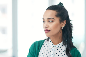 Wall Mural - Determination will take you in the direction you deserve. a young businesswoman looking thoughtful in a modern office.