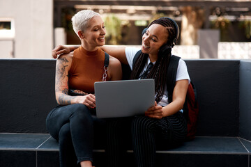 Aufkleber - Besties follow the same trends online. two attractive young women using a laptop while relaxing together outdoors.