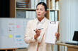 © DragonImages - Business coach showing chart to people at meeting and explaining details
