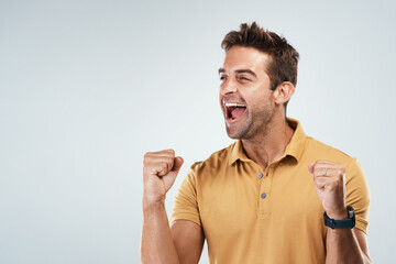 Aufkleber - I want to feel like this forever. Studio shot of a cheerful young man punching the air in excitement while standing against a grey background.