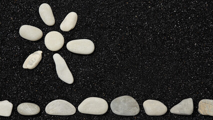 Wall Mural - black sand with sun symbol of pebbles - background