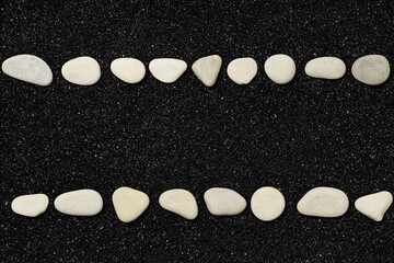 Wall Mural - black beach sand with lines of pebbles - background