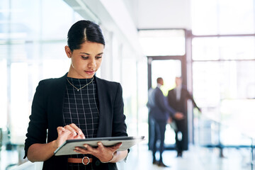 Poster - Working hard is good, but working smart is better. an attractive young businesswoman using a digital tablet in an office with her colleagues in the background.