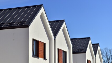 Wall Mural - Terraced family homes in newly developed housing estate. The real estate market in the suburbs. New single family houses in a new development area. Residential homes with modern facade. 