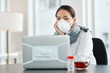 © N F/peopleimages.com - Its tough out there, keep your health strong. a masked young businesswoman working with hand sanitiser, a laptop and herbal tea at her desk.