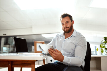 Poster - Working with apps is just smarter for my business. Portrait of a young businessman using a digital tablet in an office.