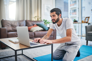 Poster - I need some inspiration for my workout. a man using his laptop while practising yoga at home.