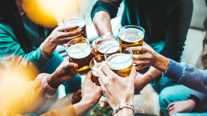 Group of people drinking beer at brewery pub restaurant - Happy friends enjoying happy hour sitting at bar table - Closeup image of brew glasses - Food and beverage lifestyle concept