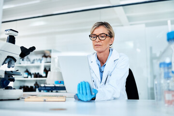Poster - Recording and analysing data at hand. a mature scientist using a digital tablet in a lab.