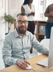 Aufkleber - There is no limit to what he can achieve. Cropped portrait of a handsome young businessman sitting and using a computer while his colleagues work in the background.