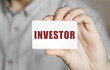 © MP Studio - Card with text INVESTOR in a man's hand