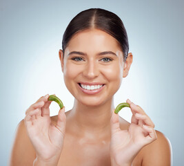 Poster - Portrait of smiling beautiful woman using aloe vera in skincare routine. Caucasian model isolated against grey studio background and posing with copyspace. Organic plants for hydration and moisture