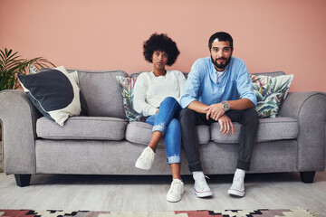 Poster - Quarantining together has its ups and downs. Portrait of a young couple sitting on the sofa at home.