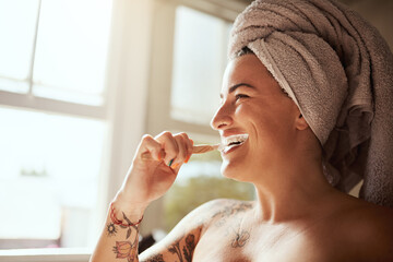 Hygiene before anything else. an attractive young woman brushing her teeth in the bathroom at home.