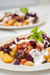 Finnish potato hash with mushroom, beefroot and carrot. Vegetarian diced panfried food with mayonnaise, ketchup and parsley on top.