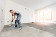 © Parilov - Floor priming process. Worker use primer on concrete floor before laying tiles, strengthening surface