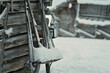 Old rustic houses made of timber and covered in snow. Some tools on the side of the wooden house. Snowy village in Lapland, Finland on a cold winter day.