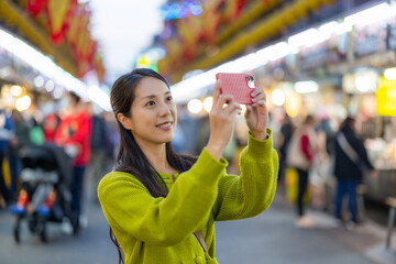 Sticker - Woman use cellphone to take photo in Keelung street market of Taiwan