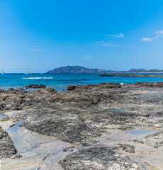 Wall Mural - A view past rock pools out into the bay at Tamarindo in Costa Rica in the dry season