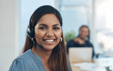 Poster - Tending to calls with a big smile and friendly manner. Portrait of a young businesswoman wearing a headset while working in an office.