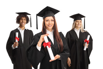 Wall Mural - Three graduate students in black gowns holding university diplomas