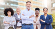 © N F/peopleimages.com - Were more powerful together. a diverse group of businesspeople standing outside on the balcony with their arms folded.