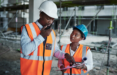 Poster - Equal hands forge firm foundations. a young man using a walkie talkie while working with his colleague at a construction site.