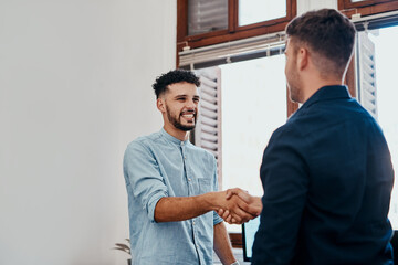 Canvas Print - Welcome aboard an awesome business. two young businessmen shaking hands in a modern office.