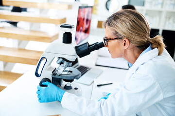 Poster - Scientists help us understand how the world works in specific ways. a mature scientist using a microscope in a lab.