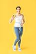 © Pixel-Shot - Beautiful young woman after weight loss with apple and measuring tape on yellow background
