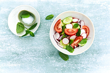 Wall Mural - Spring tomato and cucumber salad with radishes and mint leaves