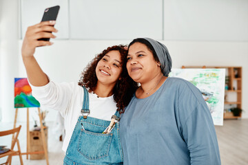 Aufkleber - Lets take a selfie. two attractive young women standing and using a cellphone to take a selfie during an art class.
