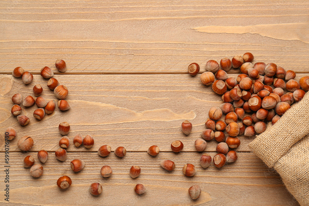 Sack bag with shelled hazelnuts on wooden background