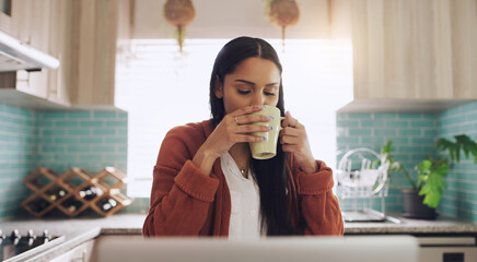 Nothing a cup of coffee to get the motor running. a young businesswoman drinking a cup of coffee while working fat home.